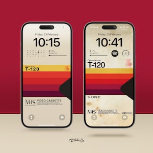 Op de afbeelding: Twee iPhone-mockups met een retro VHS-tapeontwerp. De schermen tonen de tijd, datum en batterijpercentage. De bovenkant van de telefoon heeft een zwarte cameralens en een kleine luidspreker.