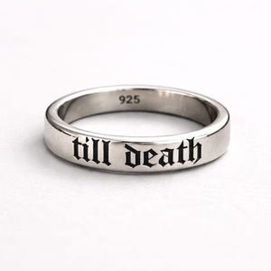 Könnte beinhalten: Ein silberner Ring mit dem eingravierten Schriftzug "till death" in gotischer Schrift. Der Ring besteht aus poliertem Metall und hat die Nummer "925" auf dem Band.