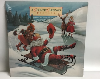 May include: A Country Christmas Volume 4 record album cover featuring a cartoon illustration of Santa Claus riding a sled with a Christmas elf. The album cover also features a reindeer and a woman in a red dress.