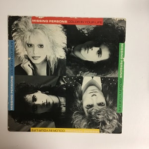 May include: Black and white photo of a band called Missing Persons. The band members are all looking at the camera. The band's name and album title "Color in Your Life" are printed on the photo.