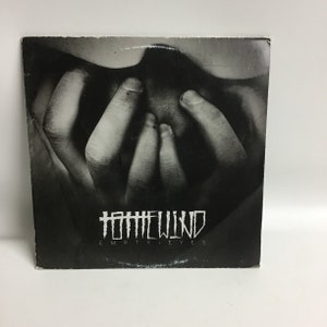 May include: Black and white album cover with a photo of hands covering a face. The album title is "HATEWIND EMPTY EYES" in a gothic font.