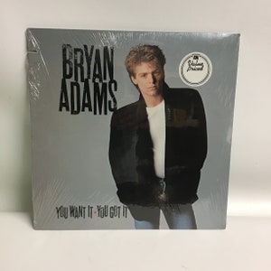 May include: A vinyl record album cover featuring a photo of Bryan Adams. The album title is "You Want It - You Got It".