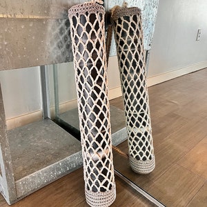 May include: A beige crochet yoga mat carrier with a brown yoga mat inside. The carrier has a drawstring closure and a long strap.