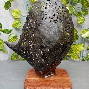This is a real and natural mother of pearl shell polished and hand carved with wooden stand by a very skilled carving artist in his field. It is very detailed with pegasus design and has high artistic value