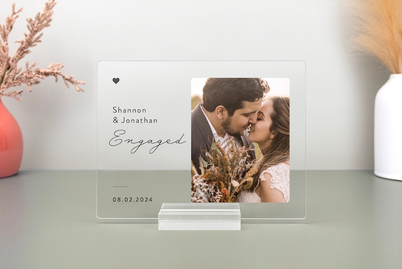 This is a personalized engagement acrylic photo plaque, a perfect keepsake to celebrate a couple's special moment. Perfect for display on a shelf, desk, or nightstand.