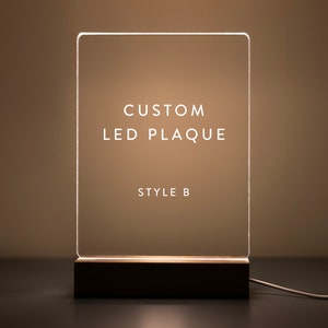 This custom LED plaque design (Style B) offers a clean and modern look. The illuminated acrylic with a wooden base provides a sophisticated touch, making it perfect for personalized messages, quotes, or photos.