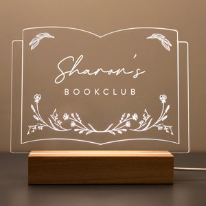 Personalized Library Sign on a clear acrylic book-shaped plaque, featuring floral details and a wood LED base.
