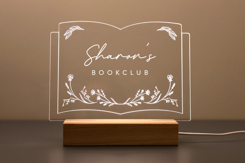 Personalized Library Sign on a clear acrylic book-shaped plaque, featuring floral details and a wood LED base.