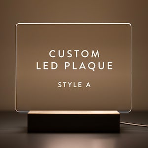 This custom LED plaque design (Style A) offers a clean and modern look. The illuminated acrylic with a wooden base provides a sophisticated touch, making it perfect for personalized messages, quotes, or photos.