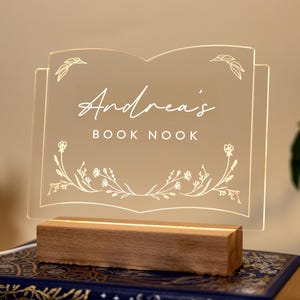 Personalized Library Sign on a clear acrylic book-shaped plaque, featuring floral details and a wood LED base.