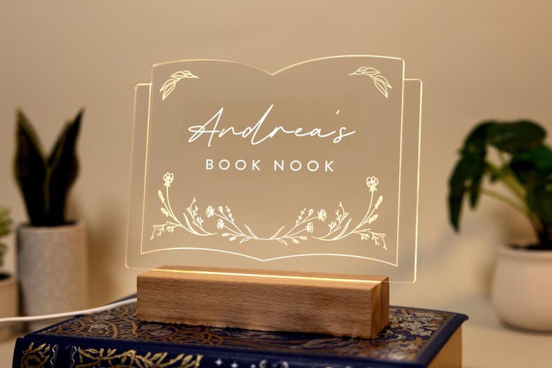 Personalized Library Sign on a clear acrylic book-shaped plaque, featuring floral details and a wood LED base.