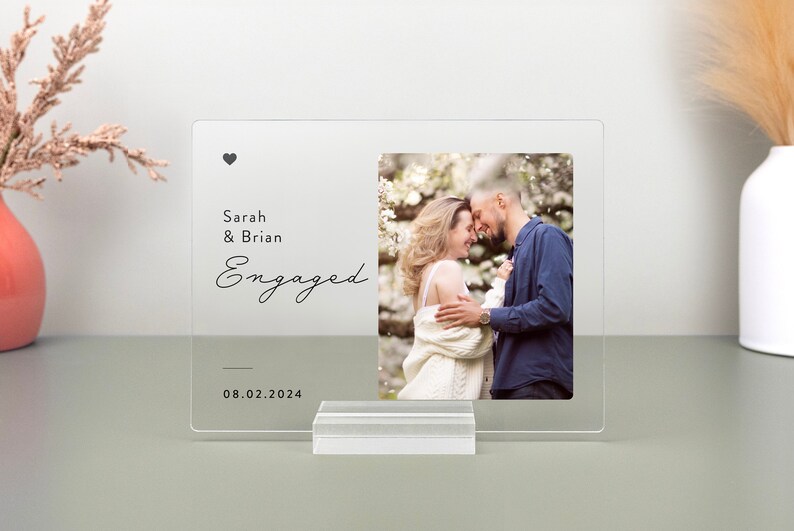 This is a personalized engagement acrylic photo plaque, a perfect keepsake to celebrate a couple's special moment. Perfect for display on a shelf, desk, or nightstand.