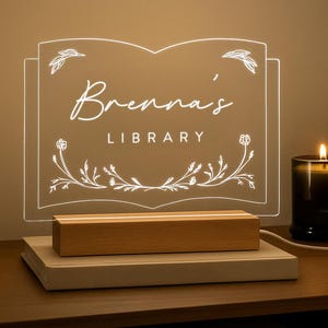 Personalized Library Sign on a clear acrylic book-shaped plaque, featuring floral details and a wood LED base.