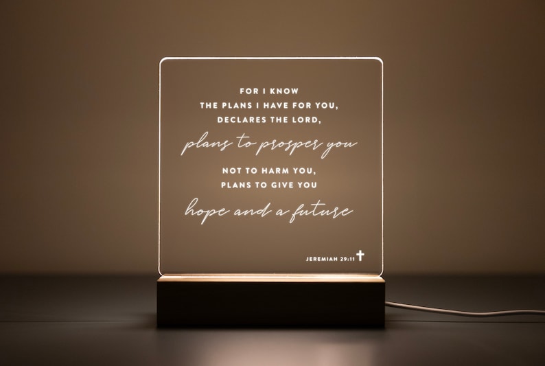 Personalized LED light featuring the uplifting Bible verse from Jeremiah 29:11: "For I know the plans I have for you, declares the Lord, plans to prosper you, not to harm you, plans to give you hope and a future." Engraved on a clear acrylic plaque with a warm wooden base, perfect for home décor, prayer corners, or as a thoughtful Christian gift.