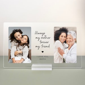 May include: A clear acrylic photo frame with two photos of mothers and daughters. The text in the frame reads "Always my mother forever my friend" with a heart symbol and "I love you, Maria".