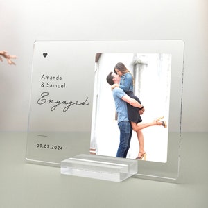 This is a personalized engagement acrylic photo plaque, a perfect keepsake to celebrate a couple's special moment. Perfect for display on a shelf, desk, or nightstand.
