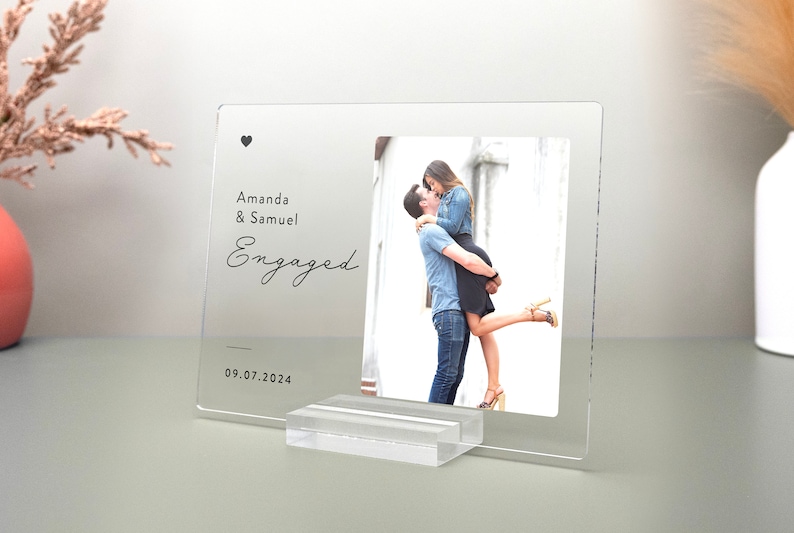 This is a personalized engagement acrylic photo plaque, a perfect keepsake to celebrate a couple's special moment. Perfect for display on a shelf, desk, or nightstand.