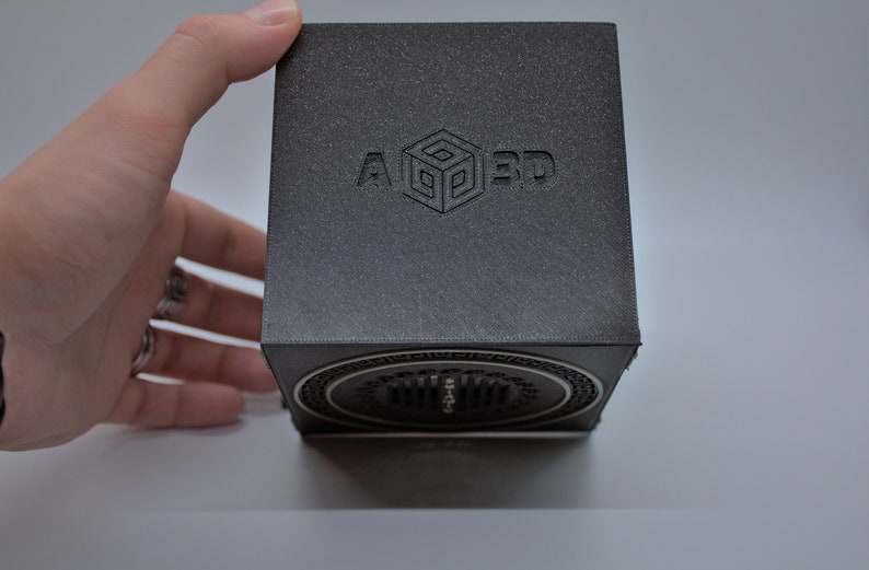 May include: A black cube with a speaker on the bottom. The cube has the text "A 3D" embossed on the top.