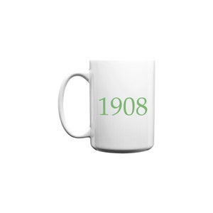 Puede incluir: Taza de café de cerámica blanca con un 1908 verde impreso en la parte delantera.
