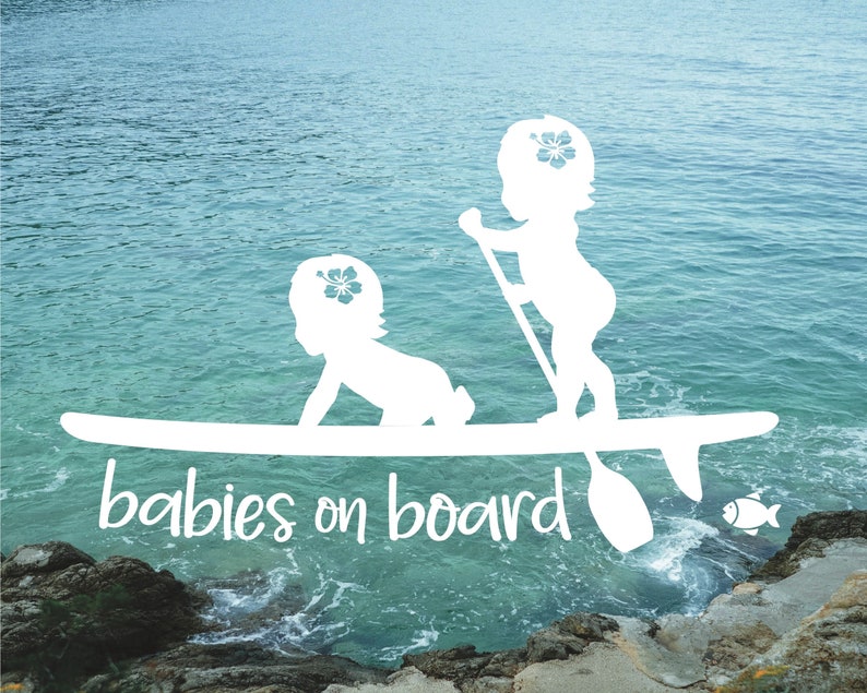 May include: White silhouette of two babies on a surfboard with the text "babies on board" in white. The background is a blue ocean with a rocky shore.