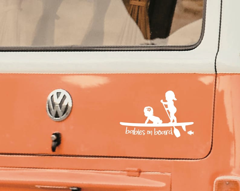 May include: White vinyl sticker with a silhouette of two children on a paddleboard. The text "babies on board" is below the image.