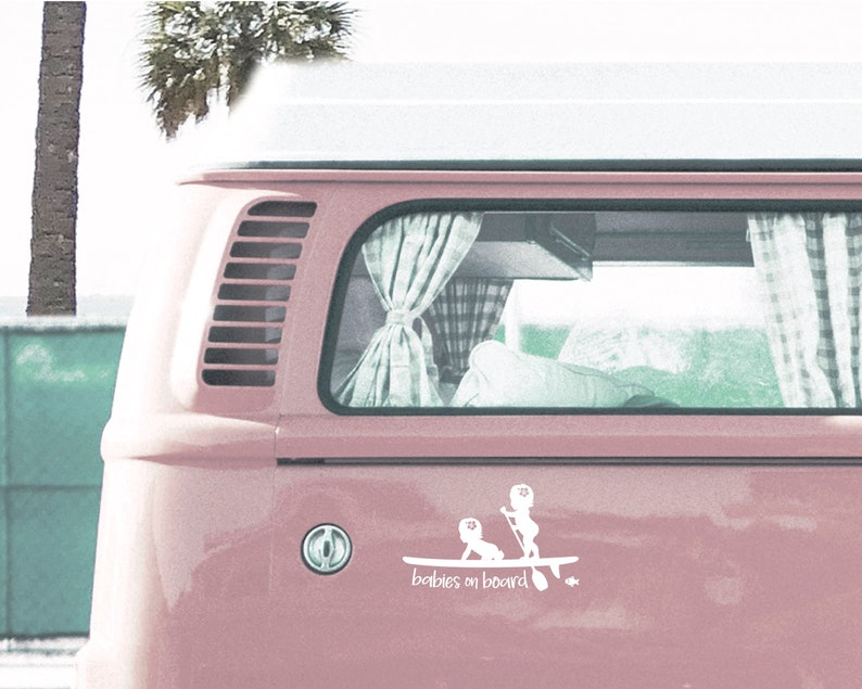 May include: A pink vintage van with a white sticker on the back that says "babies on board". The sticker shows two children on a surfboard.