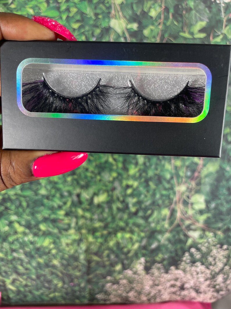 May include: A pair of black false eyelashes in a black and iridescent packaging. The eyelashes are long and full, with a wispy, layered design.