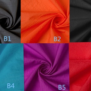 K&ouml;nnte beinhalten: Sechs Stoffmuster in verschiedenen Farben: Schwarz, Orange, T&uuml;rkis, Lila, Rot und Schwarz. Jedes Muster ist mit einem Buchstaben und einer Nummer von B1 bis B6 gekennzeichnet.