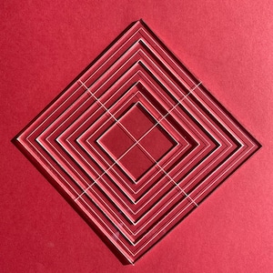 May include: A clear acrylic template with a series of concentric squares, creating a geometric pattern. The template is on a red background.