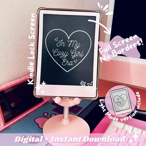 May include: A pink Kindle lock screen displays the text "In My Cozy Girl Era" inside a heart. The screen is in a pink case and mounted on a pink stand. The image includes the text "Digital + Instant Download".