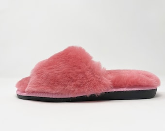 May include: A pair of pink fluffy slippers with a black sole.