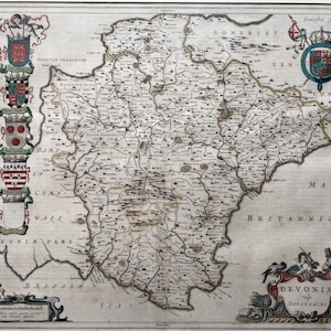 May include: An antique map of the county of Devon, England, with a coat of arms in the upper right corner and a decorative border around the map. The map is titled "DEVONIA" and "The Devon-shire".