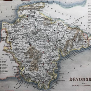 May include: A vintage map of Devonshire, England, showing the county's coastline, rivers, and towns in detail. The map is printed in black and white with coloured accents, including blue for water, green for land, and yellow for towns. The map includes a key with symbols for cities, towns, villages, roads, and railways.