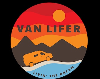 May include: A circular graphic design with a sunset scene, mountains, and a silhouette of a van. The text "VAN LIFER" is in the center of the graphic. The text "LIVIN' THE DREAM" is at the bottom of the graphic.