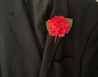 Classic, silk, red carnation buttonhole for formal occasion or wedding.