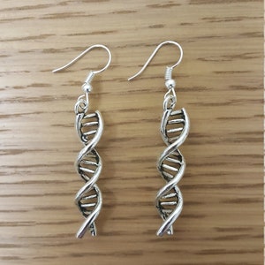 May include: A pair of silver dangle earrings featuring a DNA double helix design.