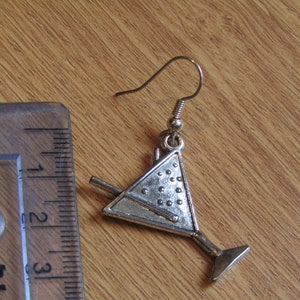 May include: Silver martini glass earring with a silver stir stick. The earring is about 1.5 inches long.