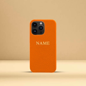 Gepersonaliseerde oranje kiezelkleurige leren telefoonhoes, iPhone 12, 12 Pro, 12 Pro Max, 13, 13 Pro en 13 Pro Max met aangepaste naam of initialen.