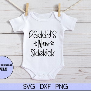May include: White baby onesie with black text that reads "Daddy's New Sidekick".