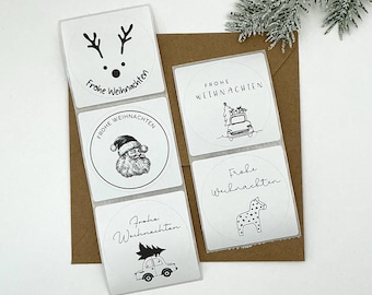 May include: A collection of white, square stickers with black illustrations and text, arranged on a brown envelope. The stickers feature festive designs like a reindeer, Santa Claus, a car with a Christmas tree, and a dotted horse. The text on the stickers reads "Frohe Weihnachten".