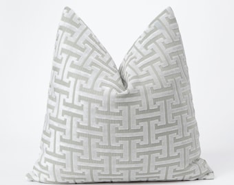 Puede incluir: Una almohada de tiro con un diseño geométrico blanco y gris.