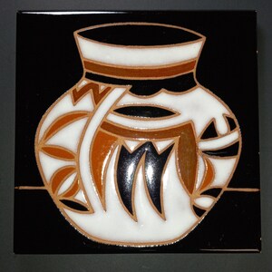 May include: Square ceramic tile featuring a stylized white vase design with brown, black, and orange accents against a black background. The vase has a geometric pattern and is outlined with a thin brown border. The tile is square.