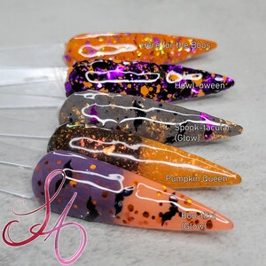 May include: Five different nail polishes with Halloween themes. The polishes are in a gradient of orange, purple, grey, black, and orange. The names of the polishes are "Here for the Boos", "Howl-oween", "Spook-tacular (Glow)", "Pumpkin Queen", and "Boo-tiful (Glow)".