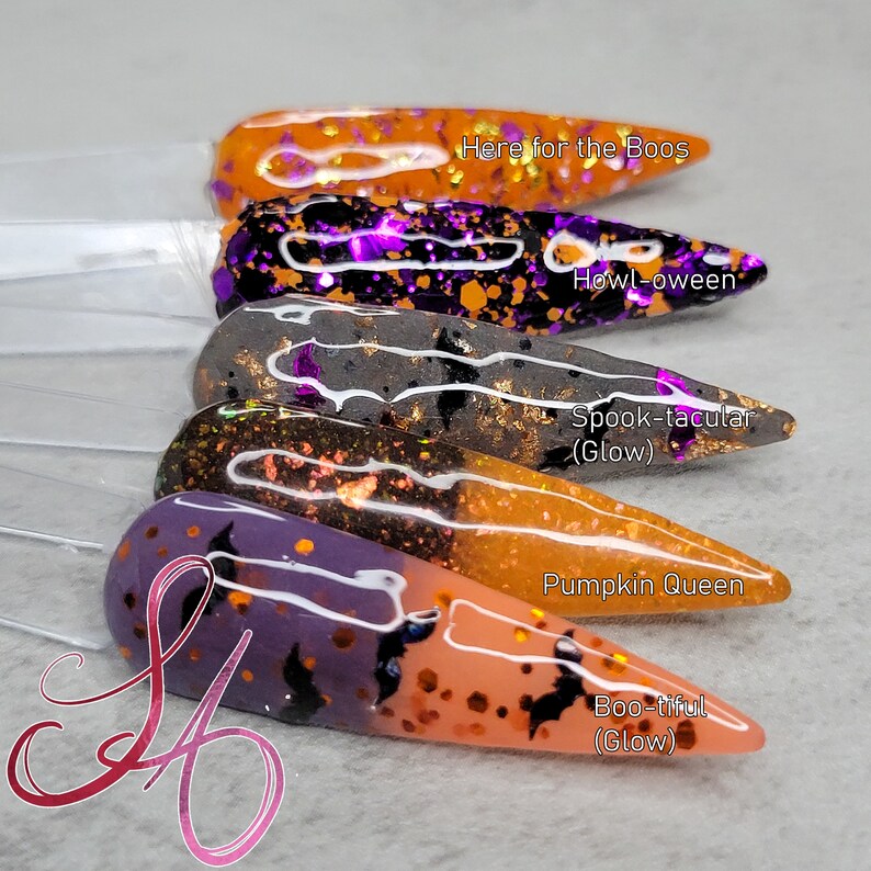 May include: Five different nail polishes with Halloween themes. The polishes are in a gradient of orange, purple, grey, black, and orange. The names of the polishes are "Here for the Boos", "Howl-oween", "Spook-tacular (Glow)", "Pumpkin Queen", and "Boo-tiful (Glow)".
