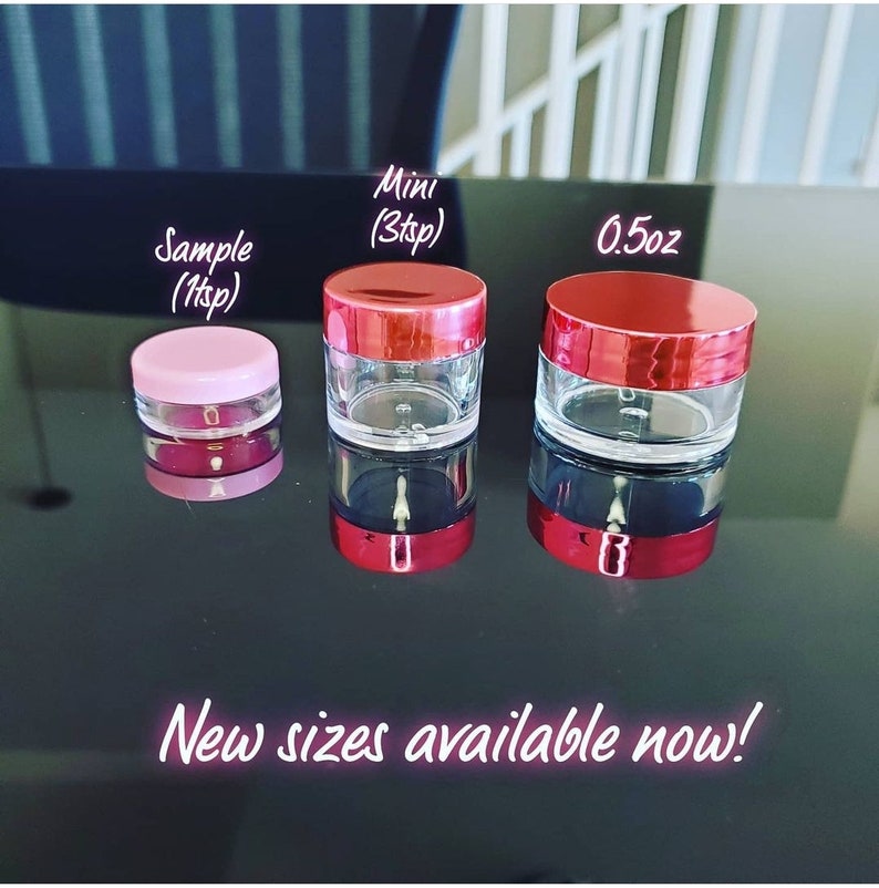 May include: Three clear plastic jars with red lids. The jars are labeled "Sample (1tsp)", "Mini (3tsp)", and "0.5oz". The jars are on a black surface. New sizes available now!