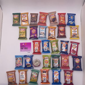 May include: A collection of miniature Lay's potato chip bags in various flavors, including Wavy, Summer BBQ, Kettle Cooked, and Bacon Mac & Cheese. The bags are arranged in rows on a white surface.