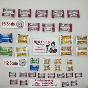 May include: A collection of miniature candy bar wrappers in 1:6 and 1:12 scale. The wrappers are in various colors, including red, yellow, blue, and green. The image includes the text "Mini Things Boutique" and "Each Sold Seperately Other Flavors may be Available but are not Pictured".