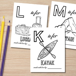 Op de afbeelding: Zwart-witte afdrukbare alfabet kleurplaten voor kinderen. De letters L, M en K worden getoond met illustraties van bagage, berg en kajak. De tekst "L is voor bagage", "M is voor berg" en "K is voor kajak" is inbegrepen. De tekst "gemaakt met liefde door" is onderaan elke pagina opgenomen.