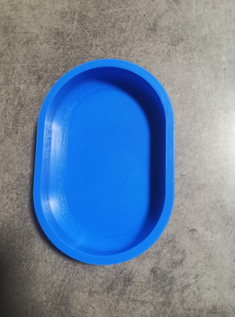 Puede incluir: Un plato ovalado de color azul brillante hecho de pl&aacute;stico. El plato es liso y tiene un ligero borde alrededor del borde.