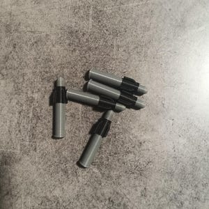 Puede incluir: Un grupo de seis tacos de pared de pl&aacute;stico gris con insertos de pl&aacute;stico negro. Los tacos est&aacute;n dise&ntilde;ados para ser utilizados con tornillos para fijar objetos a las paredes.